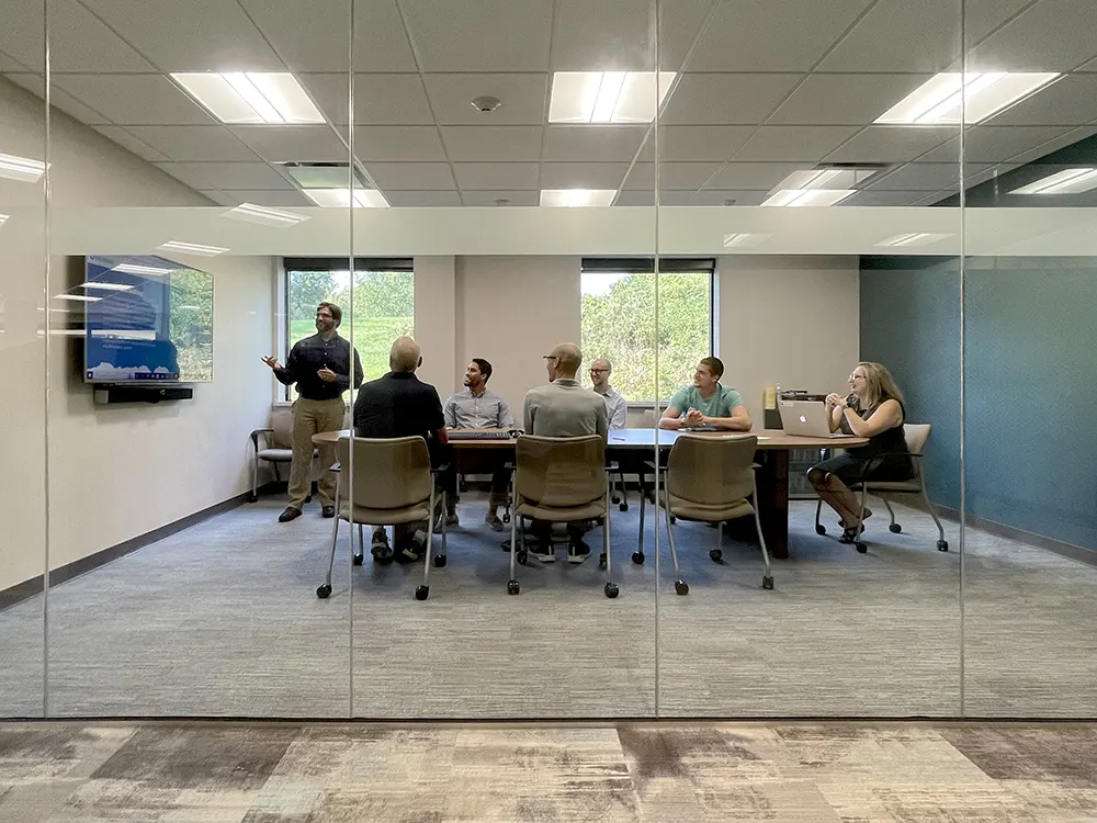 Person providing website training for a group of people in a conference room.