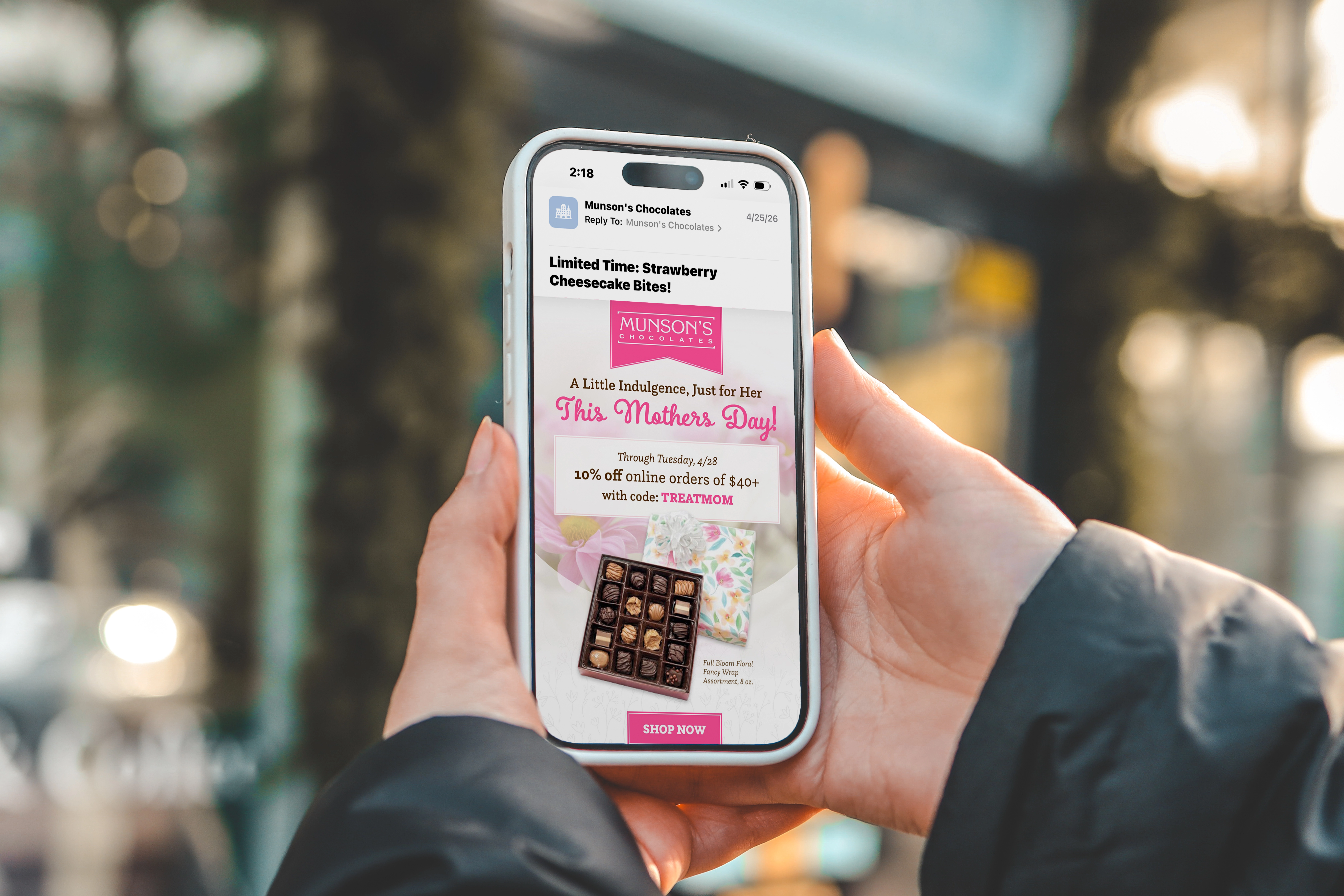 Person holding smartphone displaying holiday email marketing campaign.