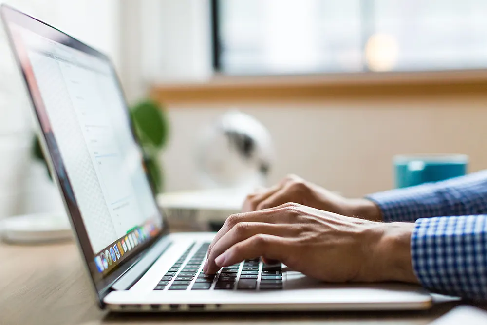 Person typing on their laptop.